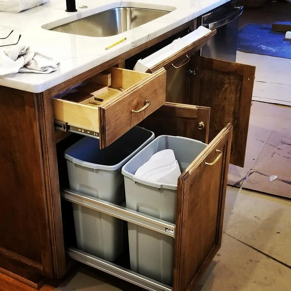 Custom kitchen island with pull-out trash storage and drawer
